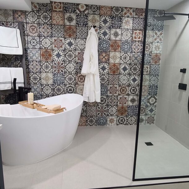 Kitchener bathroom renovation, sleek freestanding tub, shower fixtures, and a bold patterned tile accent wall.