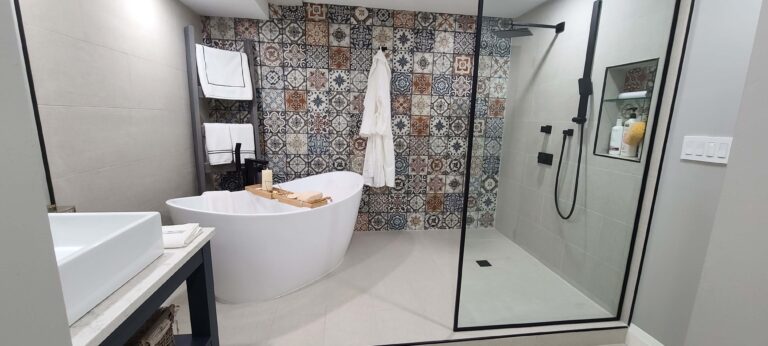 Kitchener bathroom renovation, sleek freestanding tub, shower fixtures, and a bold patterned tile accent wall.